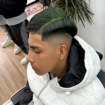 Corte de pelo con rayas definidas y un tinte de color verde en la peluquería Crownbarber de Granada, Zaidín