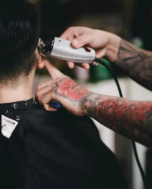 Peluquero cortando el pelo con precisión en la peluquería y barbería Crown Barber de la ciudad de Granada situada en el barrio del Zaidín